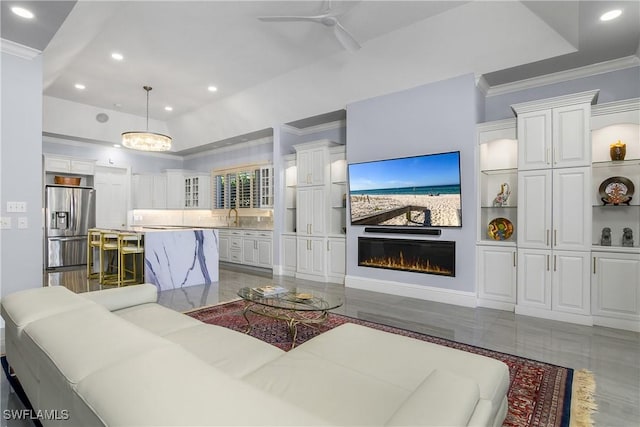 living room with a glass covered fireplace, recessed lighting, a ceiling fan, and ornamental molding