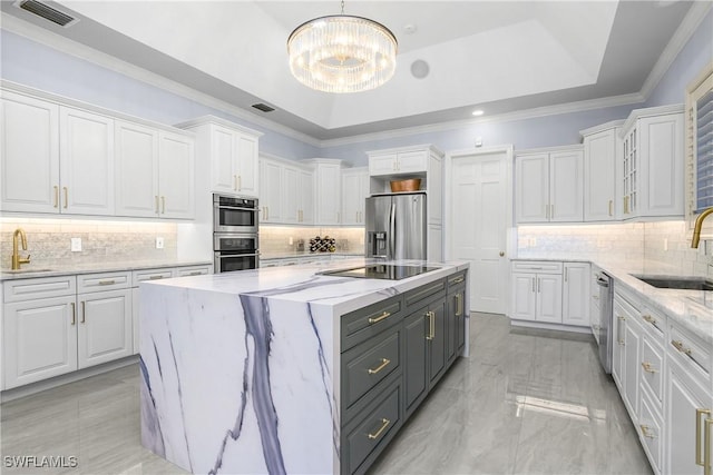 kitchen featuring stainless steel appliances, a raised ceiling, visible vents, and white cabinets