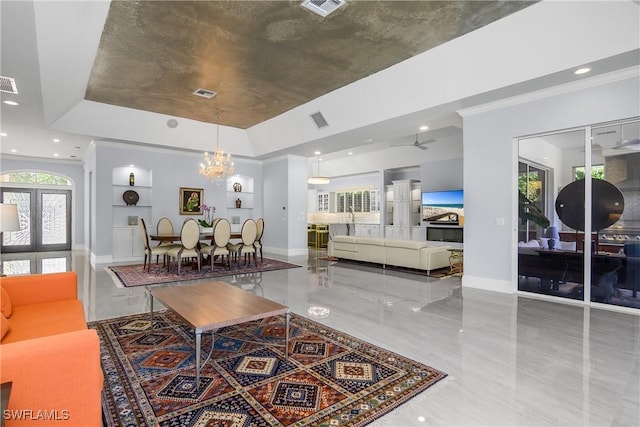 living area with baseboards, visible vents, a raised ceiling, crown molding, and french doors