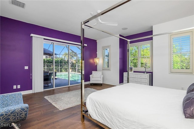 bedroom featuring access to outside, multiple windows, wood finished floors, and visible vents