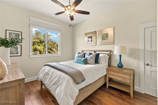 bedroom featuring dark wood finished floors, baseboards, and ceiling fan