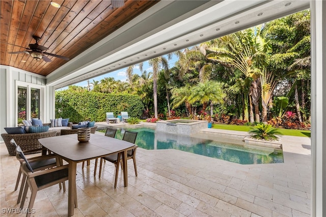 view of swimming pool featuring ceiling fan, a pool with connected hot tub, outdoor lounge area, and a patio