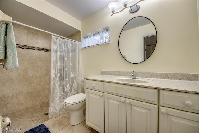 bathroom featuring toilet, a tile shower, vanity, and tile patterned floors