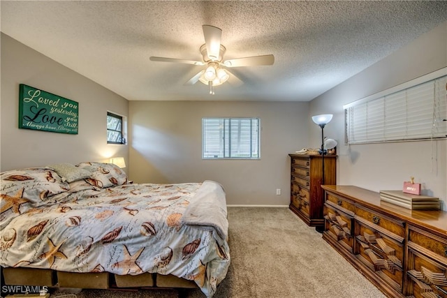 bedroom featuring a textured ceiling, baseboards, a ceiling fan, and light colored carpet