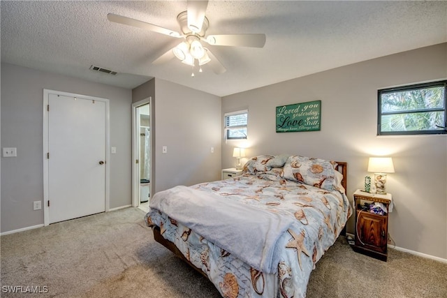 bedroom featuring ceiling fan, a textured ceiling, light carpet, visible vents, and baseboards