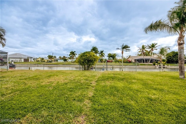 view of yard with a residential view and a water view