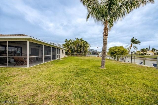 view of yard featuring a patio area, fence, a sunroom, and a ceiling fan