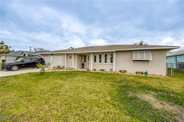 ranch-style home with a garage, fence, driveway, stucco siding, and a front yard