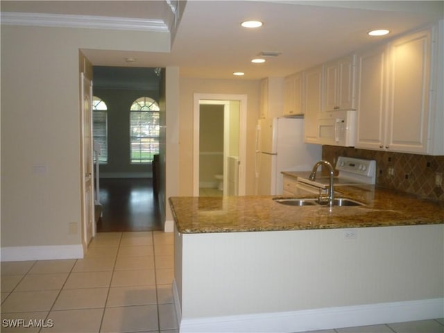 6210 Towncenter Cir, Naples, FL 34119 - kitchen featuring white cabinetry, a sink, dark stone counters, white appliances, and a peninsula