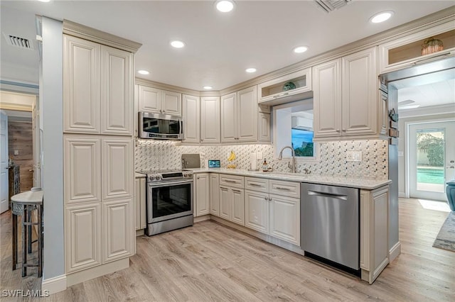 kitchen with light wood-type flooring, a sink, appliances with stainless steel finishes, and visible vents