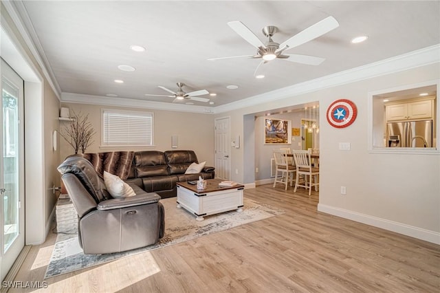 living room featuring crown molding, a ceiling fan, light wood-style flooring, baseboards, and recessed lighting
