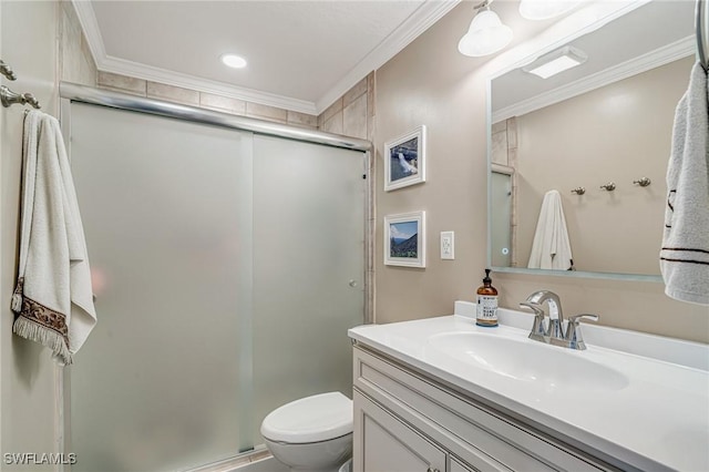 bathroom with toilet, vanity, ornamental molding, and a shower stall