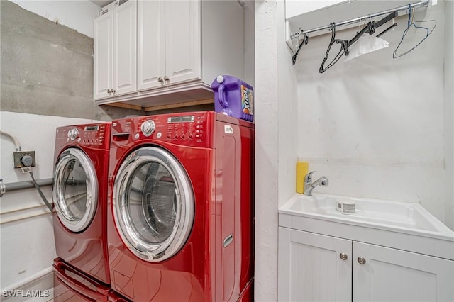 laundry area with separate washer and dryer, cabinet space, and a sink