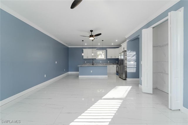 unfurnished living room featuring sink, crown molding, and ceiling fan