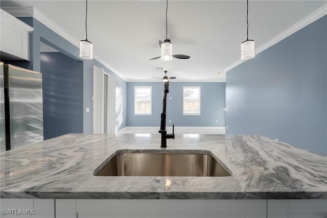 room details with white cabinetry, sink, pendant lighting, and stainless steel refrigerator