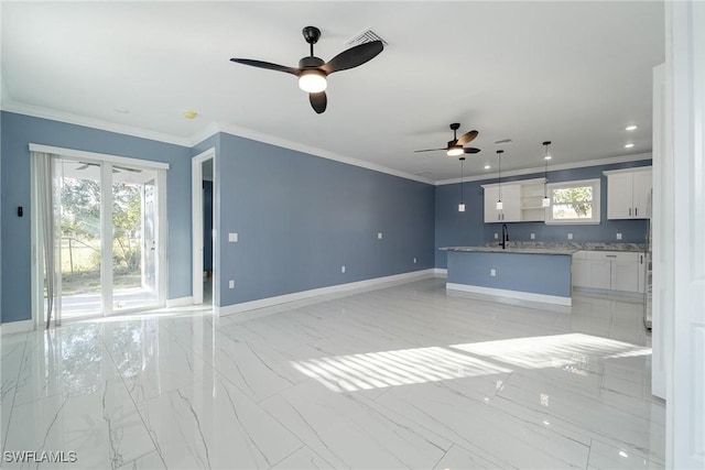 unfurnished living room featuring ornamental molding, sink, and ceiling fan