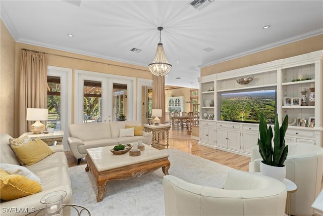 living room featuring an inviting chandelier, light hardwood / wood-style floors, french doors, and ornamental molding