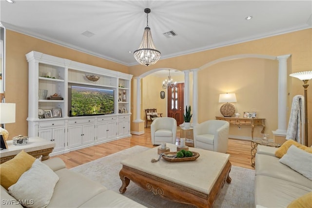 living room featuring an inviting chandelier, light hardwood / wood-style flooring, ornate columns, and ornamental molding