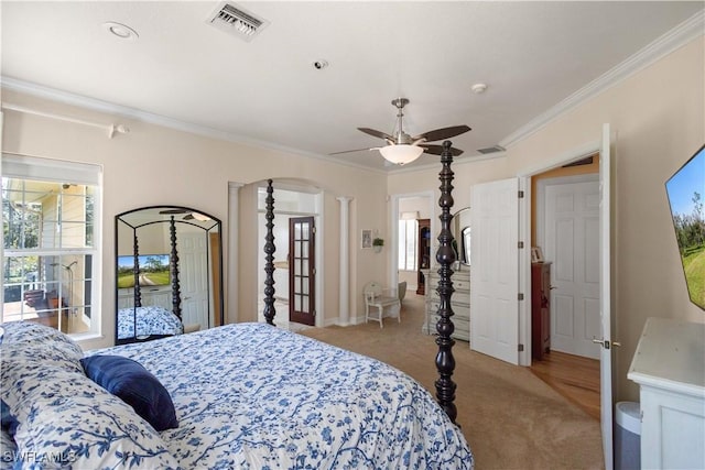 carpeted bedroom featuring decorative columns, crown molding, and ceiling fan