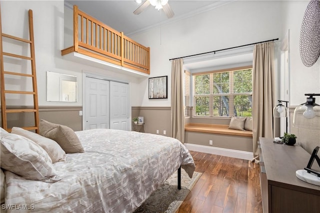 bedroom with ceiling fan, a closet, crown molding, and dark hardwood / wood-style flooring