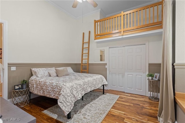 bedroom featuring hardwood / wood-style flooring, ceiling fan, a closet, and ornamental molding