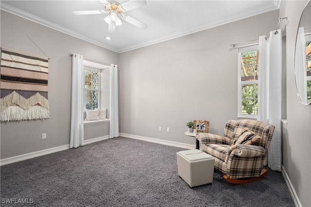 sitting room with carpet floors, ornamental molding, and ceiling fan