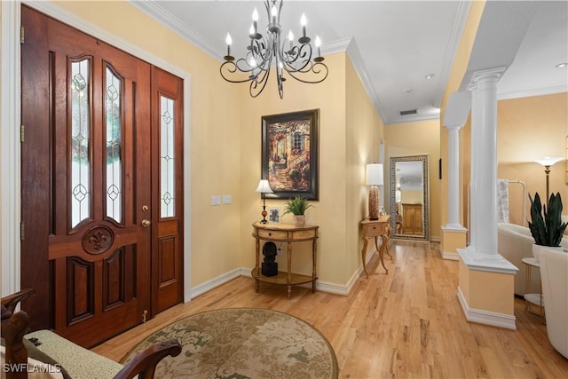 foyer with light wood-type flooring, crown molding, and decorative columns