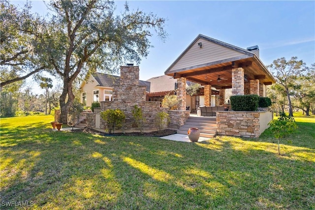 exterior space with ceiling fan and a front lawn