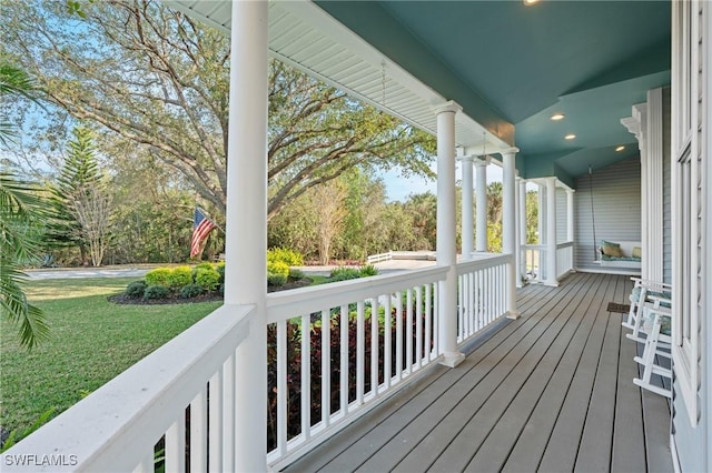 wooden terrace with a porch and a lawn