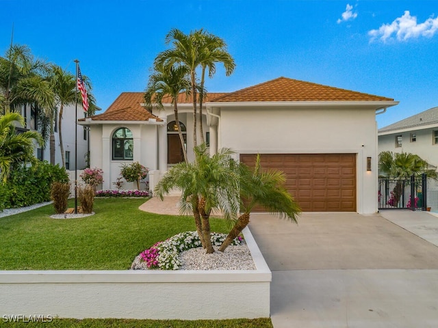 mediterranean / spanish-style house featuring a garage and a front lawn