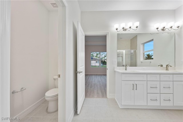 bathroom with tile patterned flooring, vanity, toilet, and a shower with shower door