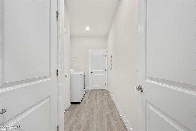 laundry area with independent washer and dryer and light wood-type flooring