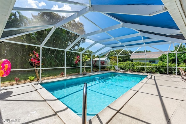 view of pool featuring glass enclosure and a patio