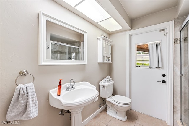 bathroom featuring sink, toilet, tile patterned flooring, and a shower with shower door