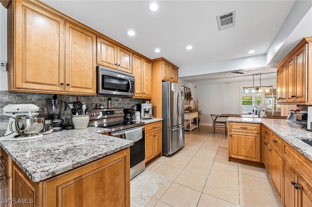 kitchen with backsplash, light stone countertops, stainless steel appliances, and decorative light fixtures