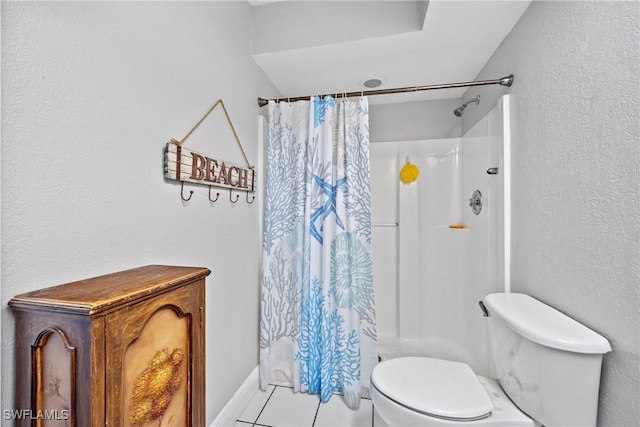 full bath featuring a textured wall, curtained shower, toilet, baseboards, and tile patterned floors