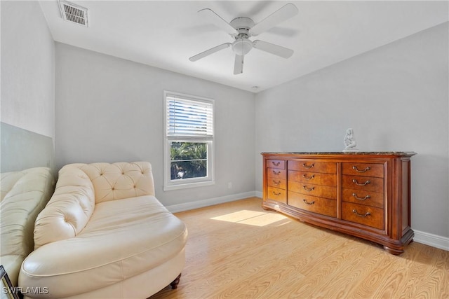 sitting room featuring light wood-type flooring, baseboards, visible vents, and a ceiling fan