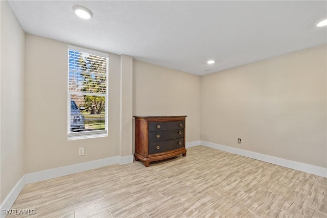 spare room featuring baseboards, wood finished floors, and recessed lighting