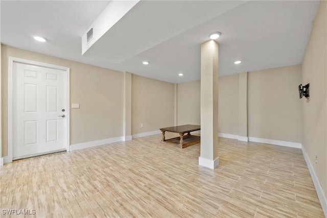 finished below grade area featuring light wood-type flooring, visible vents, baseboards, and recessed lighting