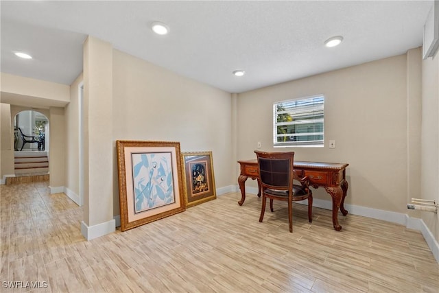 office with arched walkways, recessed lighting, light wood-style flooring, and baseboards