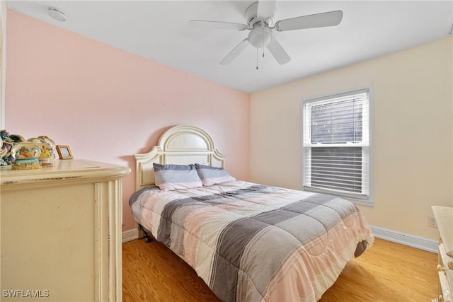 bedroom with a ceiling fan, light wood-type flooring, and baseboards