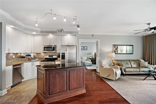 kitchen featuring visible vents, white cabinets, open floor plan, a center island, and stainless steel appliances