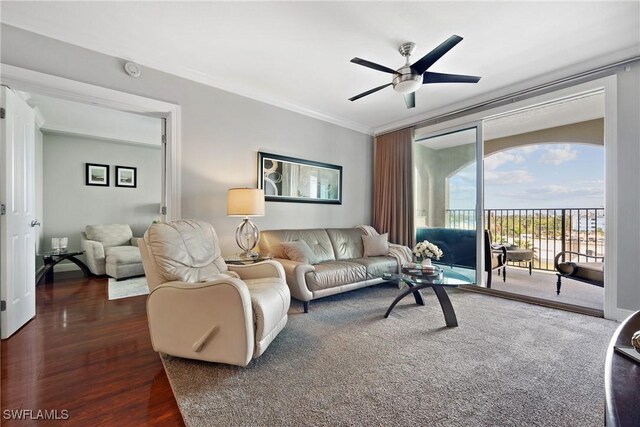 living room with dark wood finished floors, a ceiling fan, and crown molding