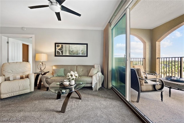 carpeted living area with a ceiling fan and crown molding