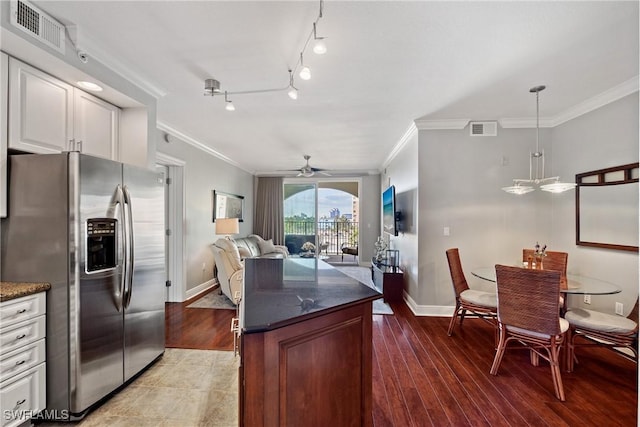 kitchen with hanging light fixtures, visible vents, stainless steel refrigerator with ice dispenser, and open floor plan