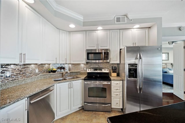 kitchen with crown molding, stainless steel appliances, a sink, and white cabinets