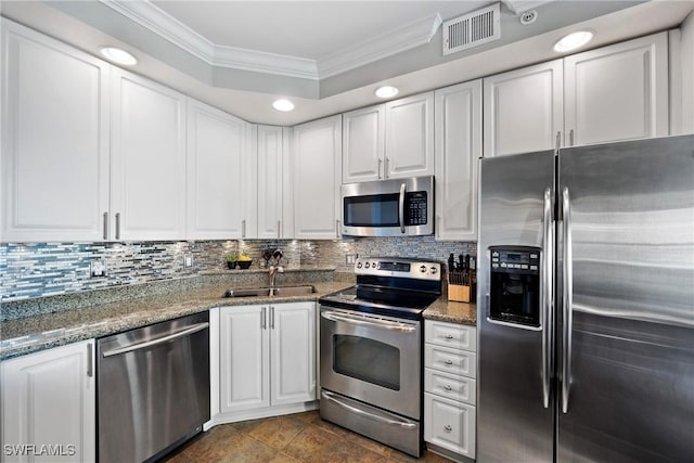 kitchen featuring visible vents, appliances with stainless steel finishes, crown molding, white cabinetry, and a sink