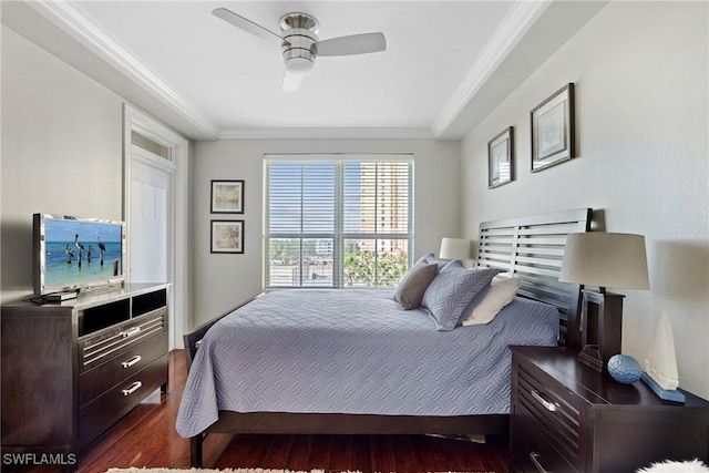 bedroom featuring dark wood-style floors, ornamental molding, and a ceiling fan