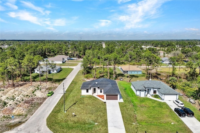 birds eye view of property featuring a residential view and a wooded view