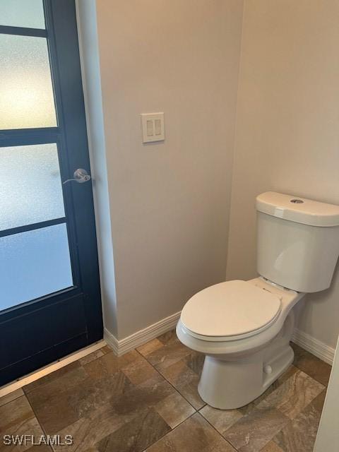 bathroom with baseboards and toilet